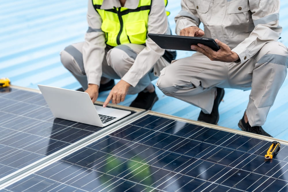 Commercial solar technician inspecting a solar panel for faults and performance issues.
